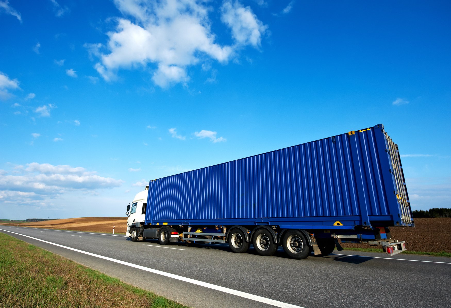 Red Lorry with Grey Trailer over Blue Sky